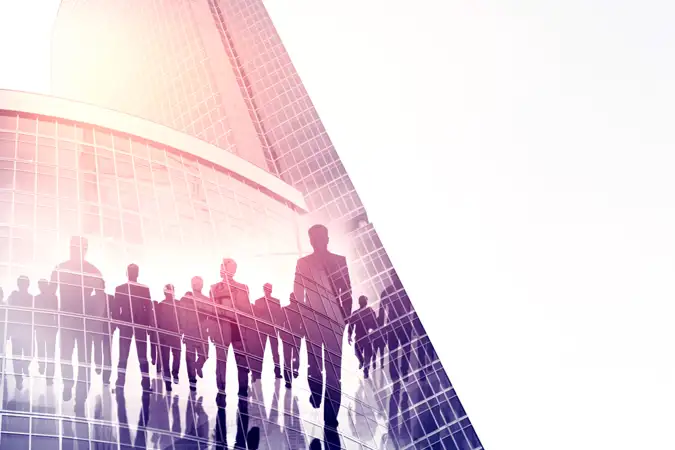 Reflection of people walking against a glass building