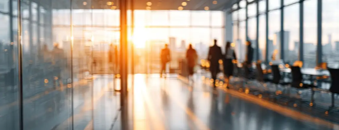 Blurry internal office view of long table with people standing near