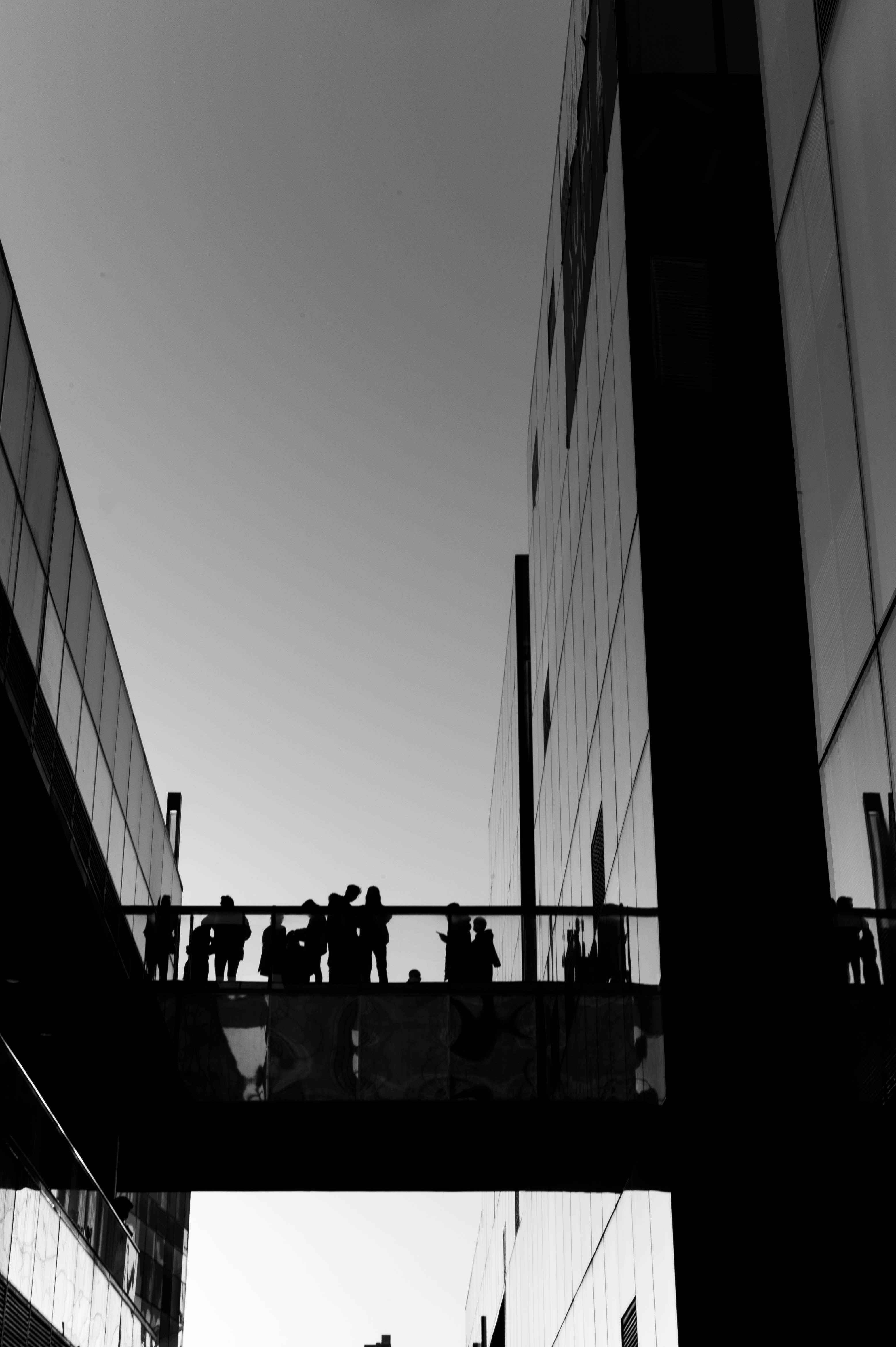 Outside office with a bridge walkway connecting them with people walking across