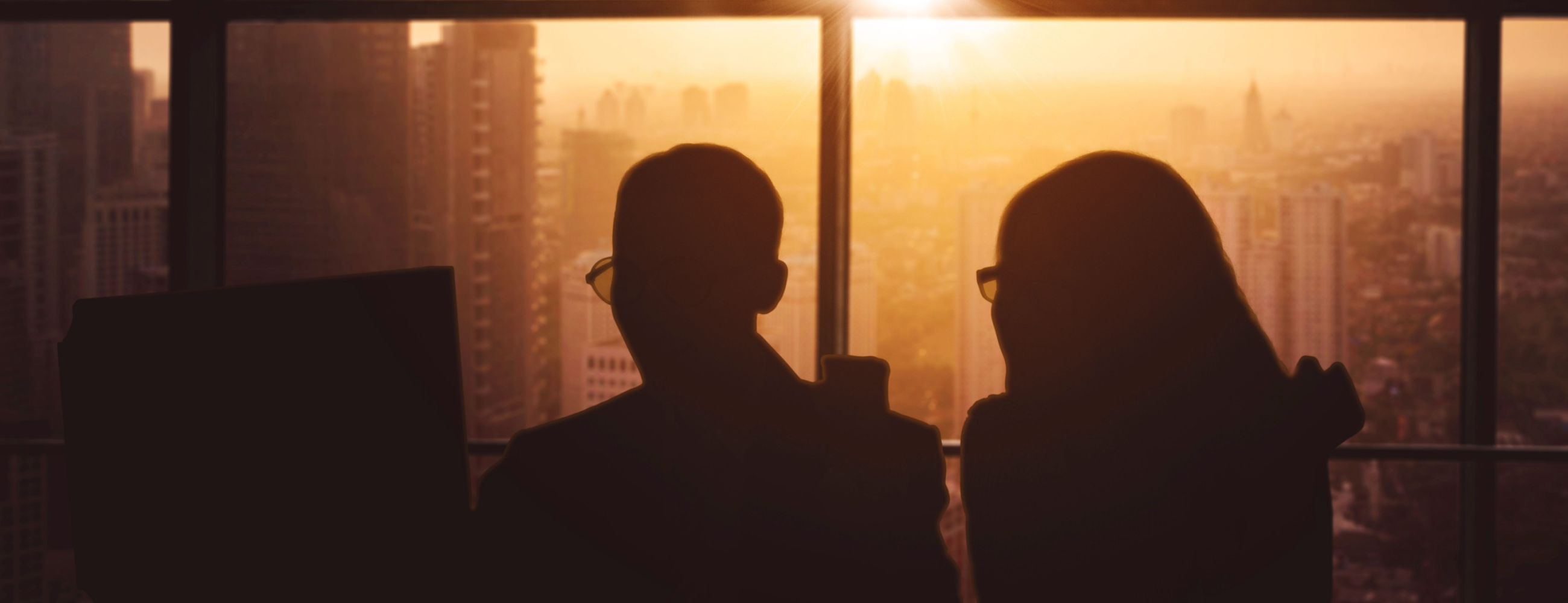 Two people working at a desk looking at the screen