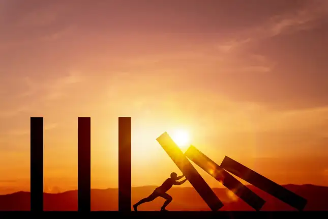 Person pushing pillars up with sunset in the background